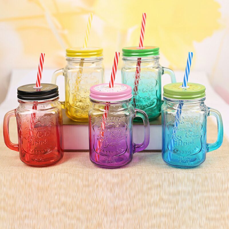 Clear glass mason jar with handle and straw, versatile for cold drinks and cocktails.